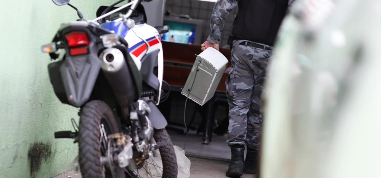 Policial levando os produtos apreendidos 